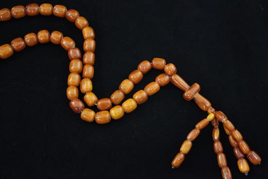 A single strand honey coloured amber bead tassel drop necklace, overall 35in.